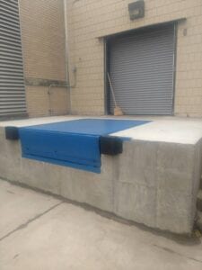 A concrete wall with blue tarp on it.