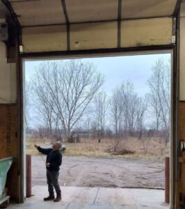 A man standing in front of an open garage door.